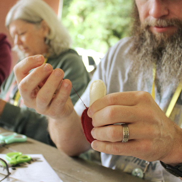Person sewing a mushroom with felt