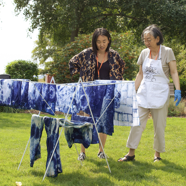 Two women looking at indigo dye